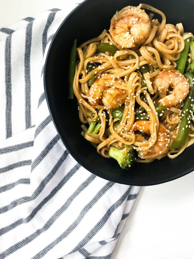 Less than 30 minutes and some pantry ingredients stand in between you and these spicy stir fried udon noodles and shrimp. Thanks to an easy Spicy Black Pepper sauce, you won't even miss takeout. #takeoutfakeout #asiannoodles #spicystirfry #30minutemeal