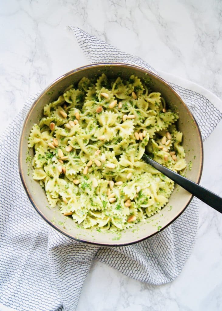 Bowtie pasta tossed with parsley pesto in a large bowl