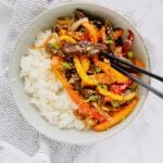 Seared beef, stir fried peppers and onions, and all tossed together with an easy homemade Korean stir fry sauce. An easy dinner that that tastes even better than takeout! Ready in under 30 minutes! Recipe at KathleensCravings.com #KathleensCravings #stirfry #koreanbeef #ricebowls #stirfrysauce #peppersandonions #30minutemeal