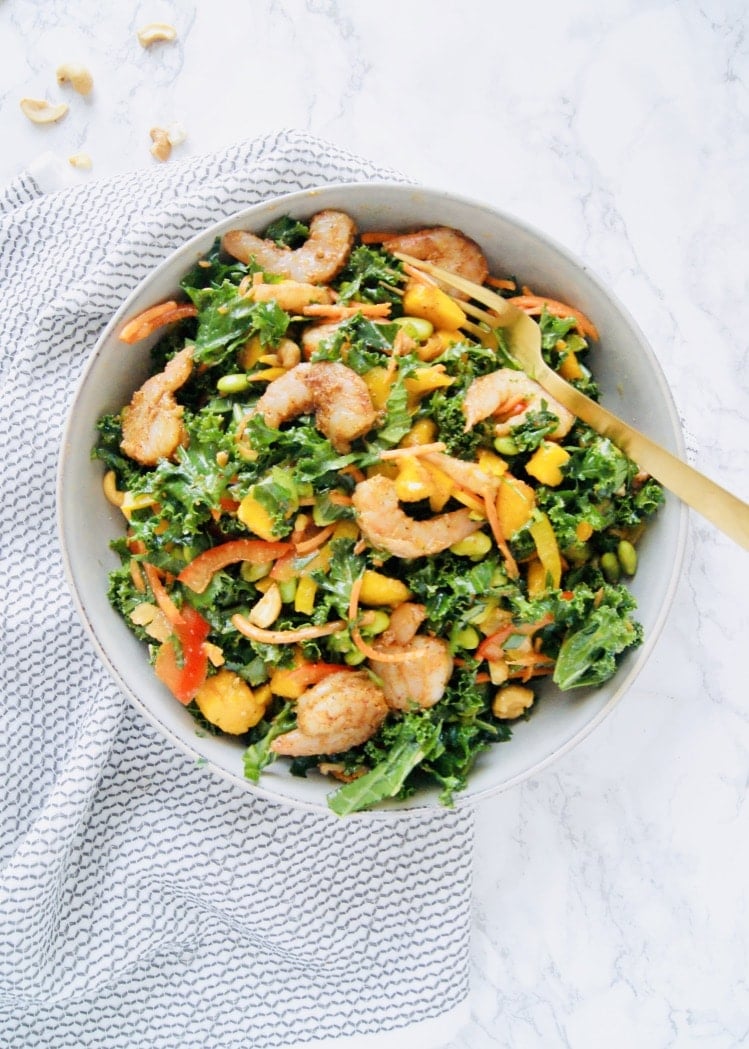 This Roasted Shrimp Thai Kale salad is light and refreshing, yet filling and big enough to serve a crowd. Lots of crunch and color and tossed with a homemade sesame dressing and topped with chili roasted shrimp. Recipe at KathleensCravings.com #thaisalad #kalesalad #shrimpsalad #saladdressingrecipe