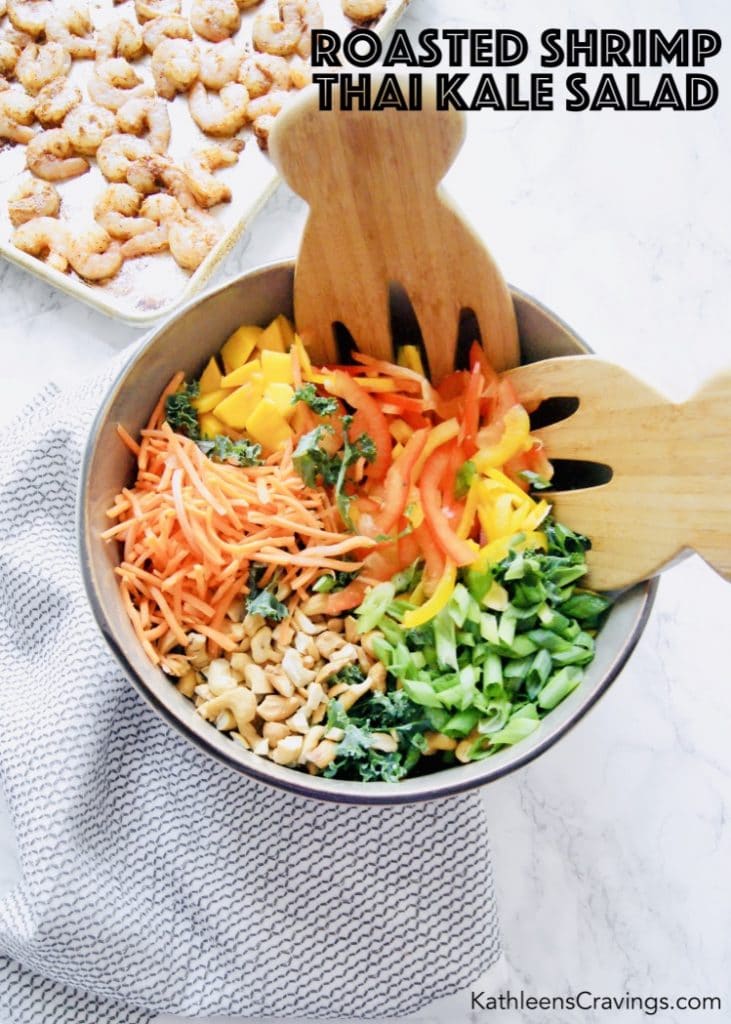 Thai salad ingredients in a large bowl with shrimp on sheet pan in background 