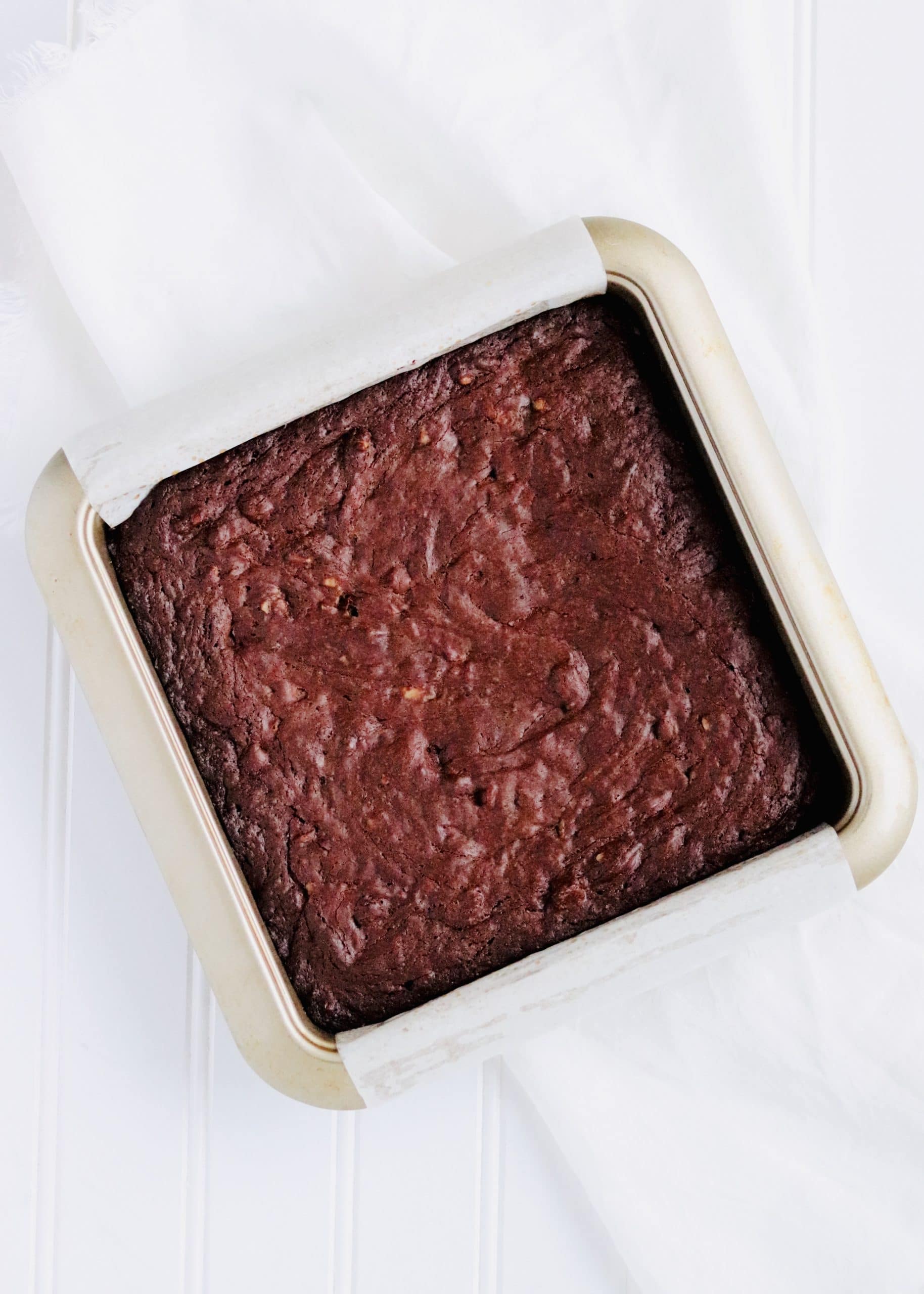 Fudgy brownies in pan with parchment paper