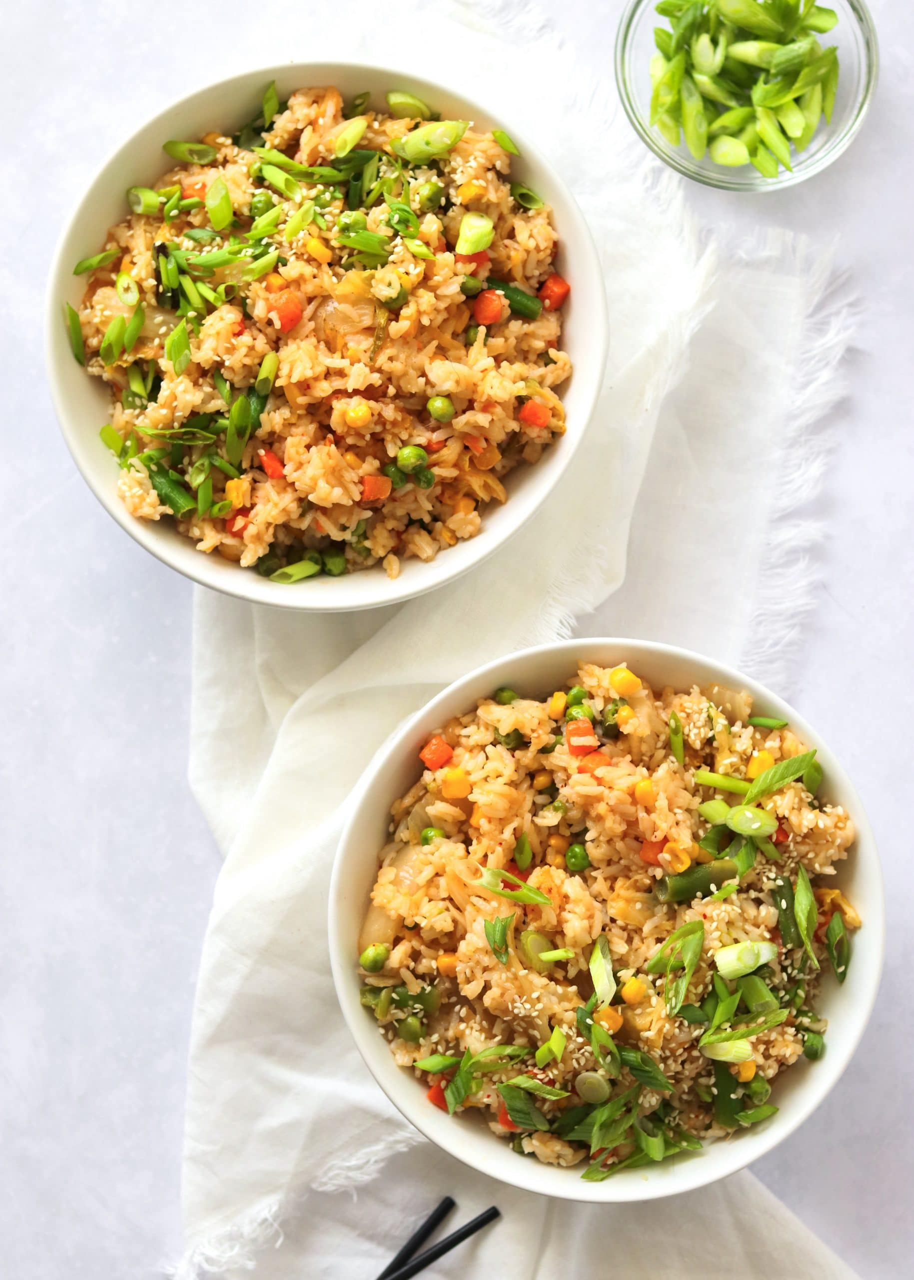 Kimchi fried rice in two bowls with chopsticks