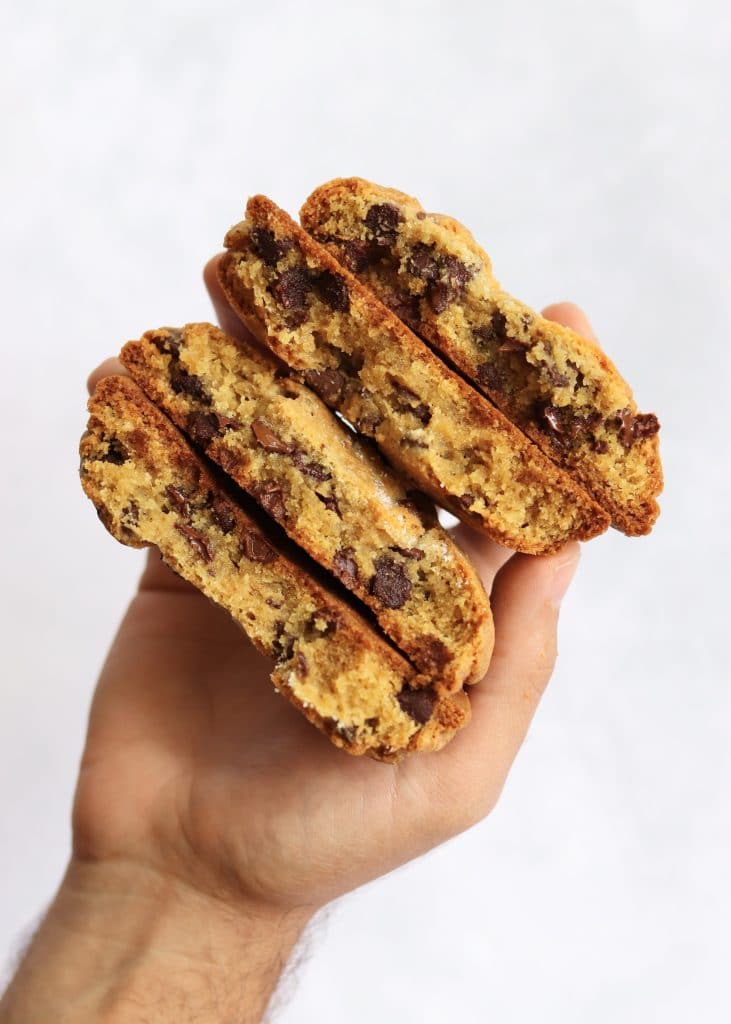 hand holding two split thick chocolate chip cookies
