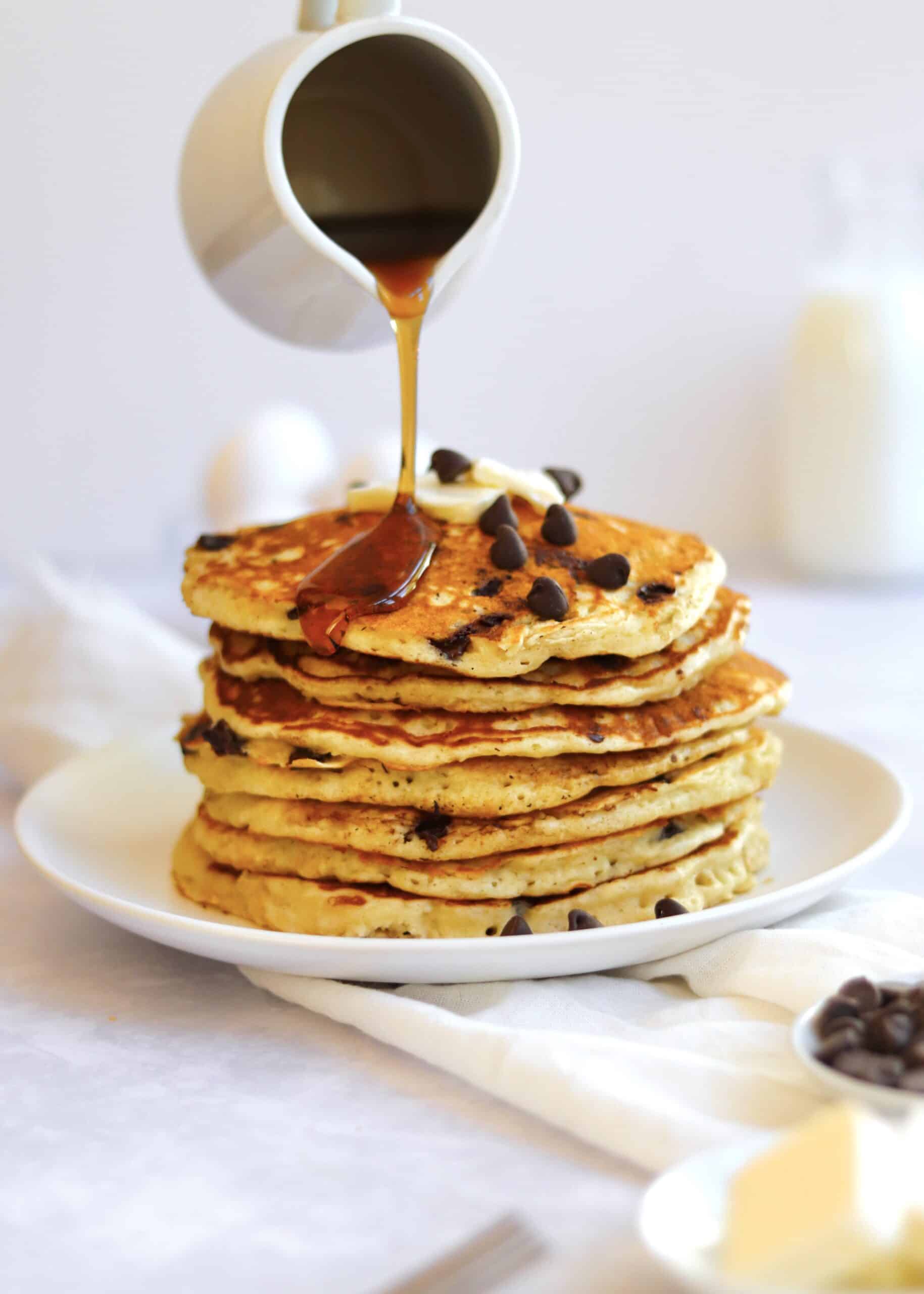 Maple Syrup being poured on chocolate chip pancakes