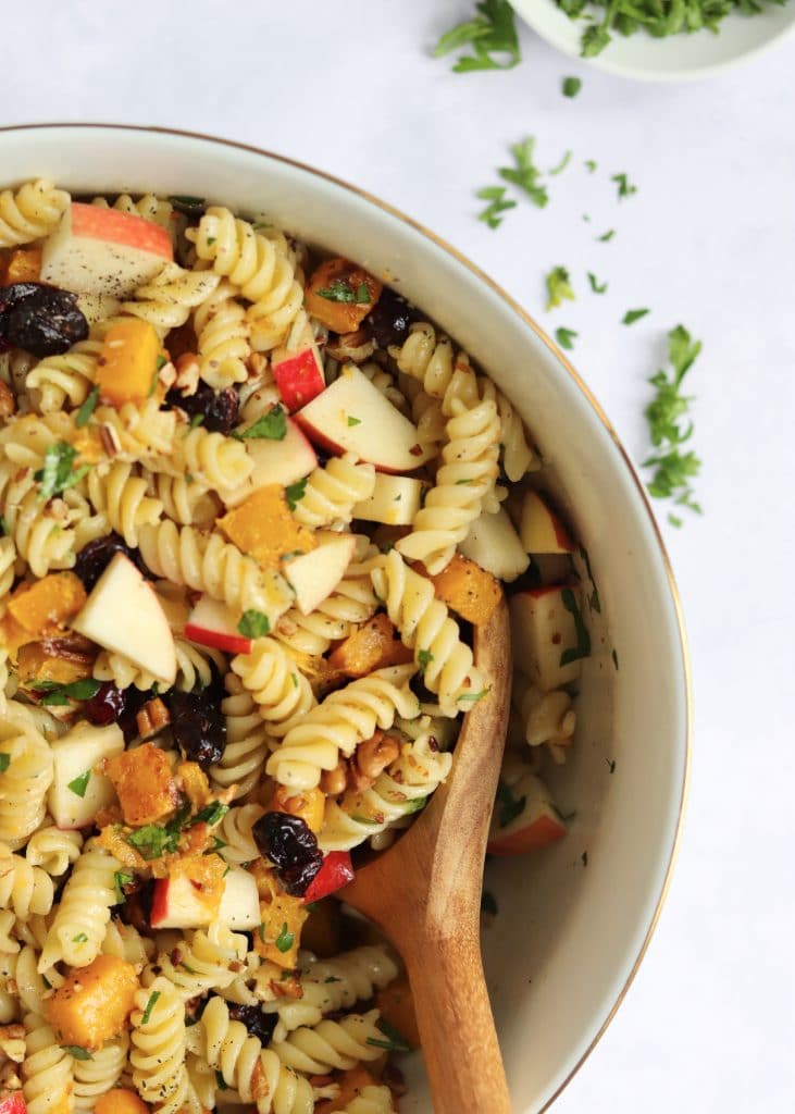 Tossed vegan pasta salad in a large bowl with fresh parsley