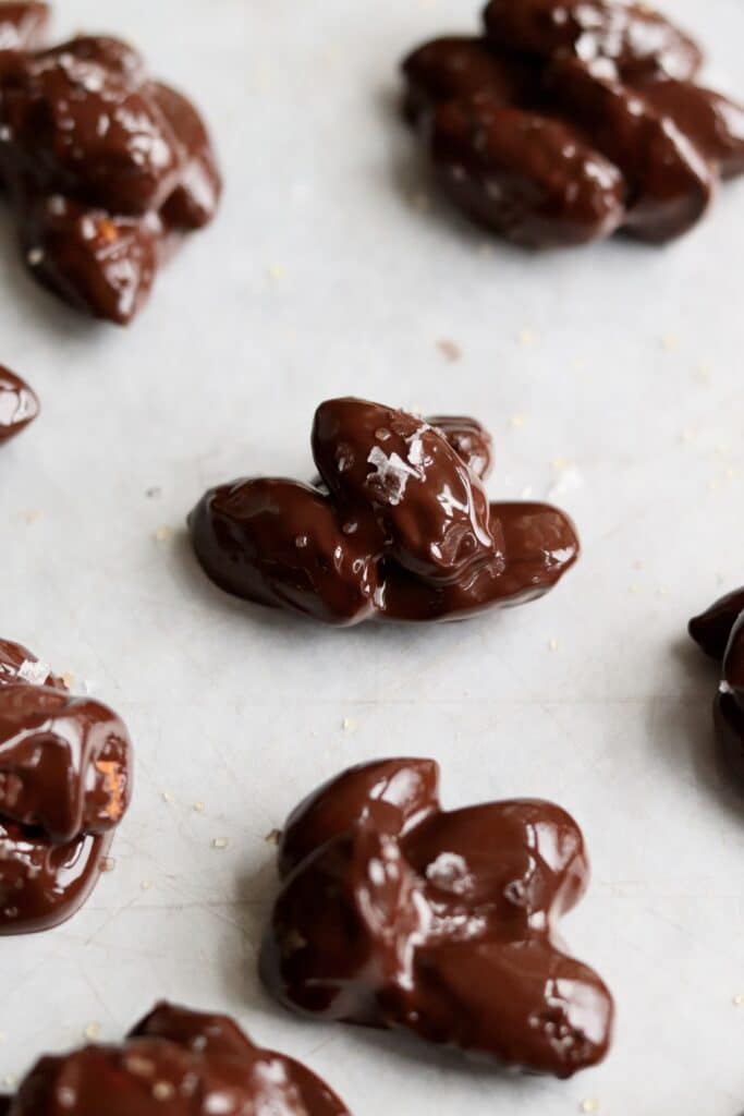Chocolate covered almonds on wax paper with sea salt