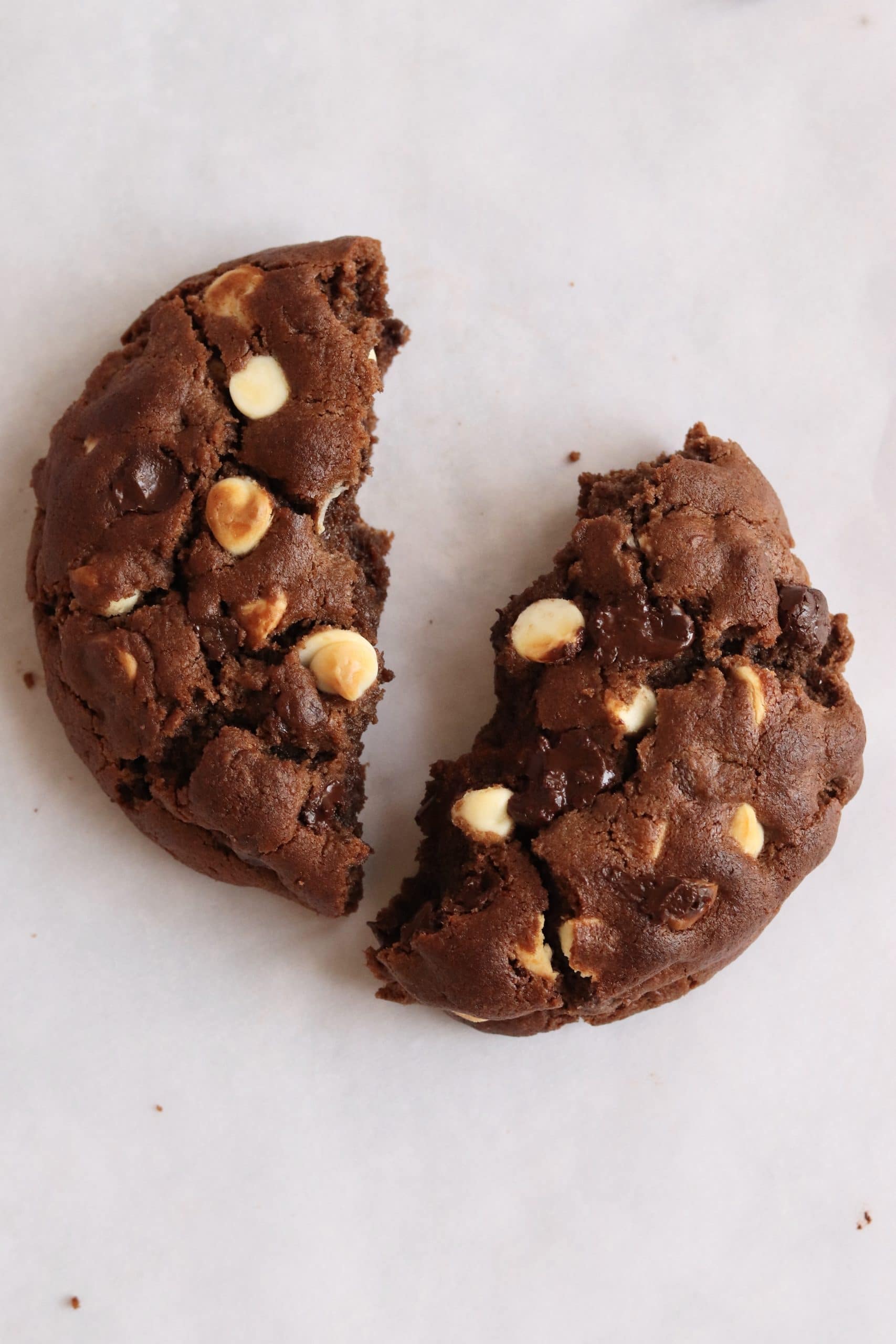 Thick triple chocolate cookie torn in half with melted chocolate