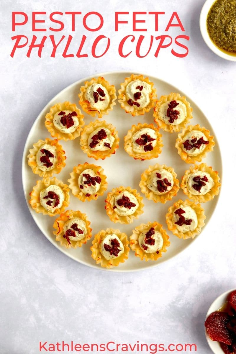 Plate of feta cream cheese phyllo cup appetizers with pesto and sun dried tomatoes