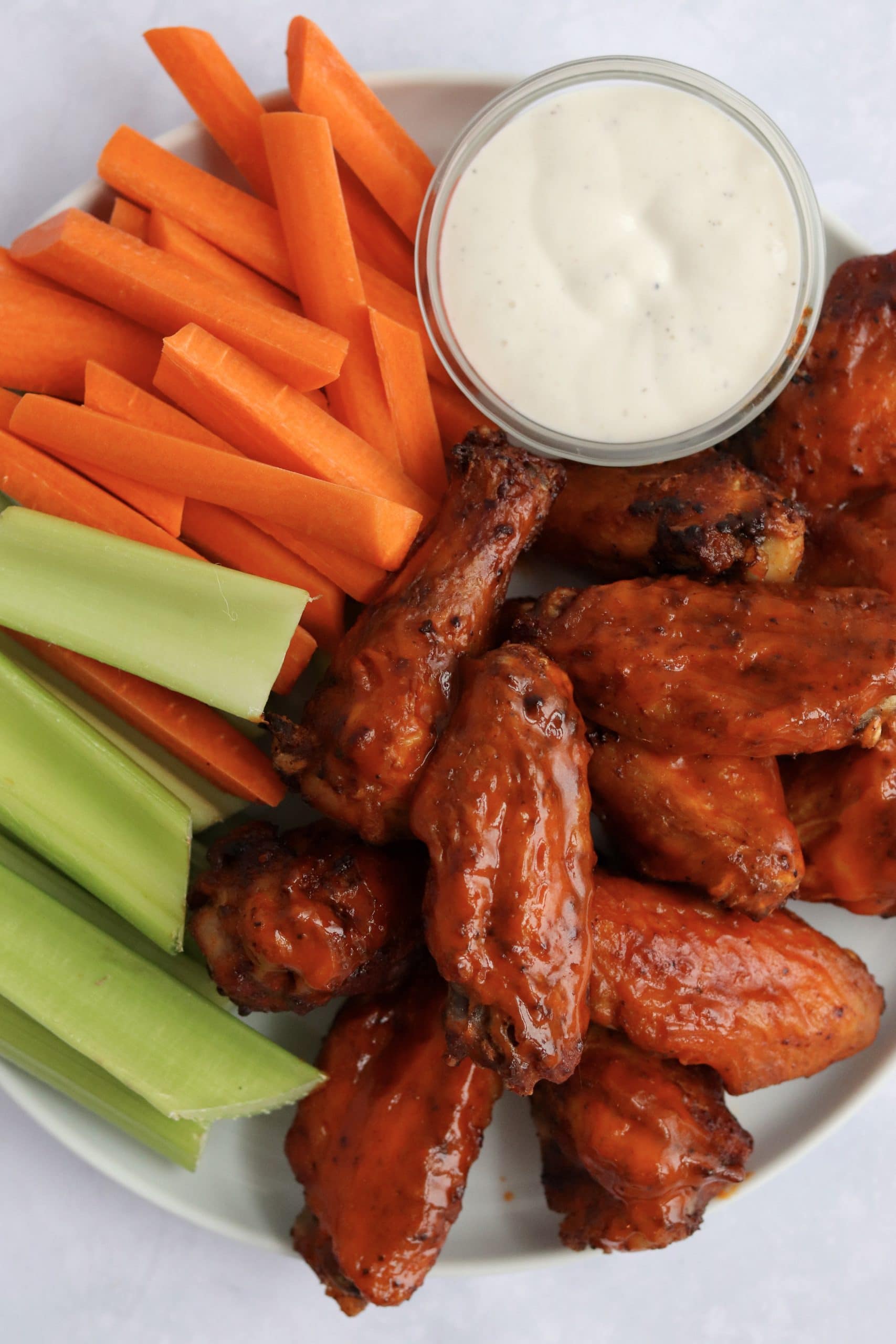 air fryer buffalo chicken wings, carrots, celery, and ranch dressing on a plate