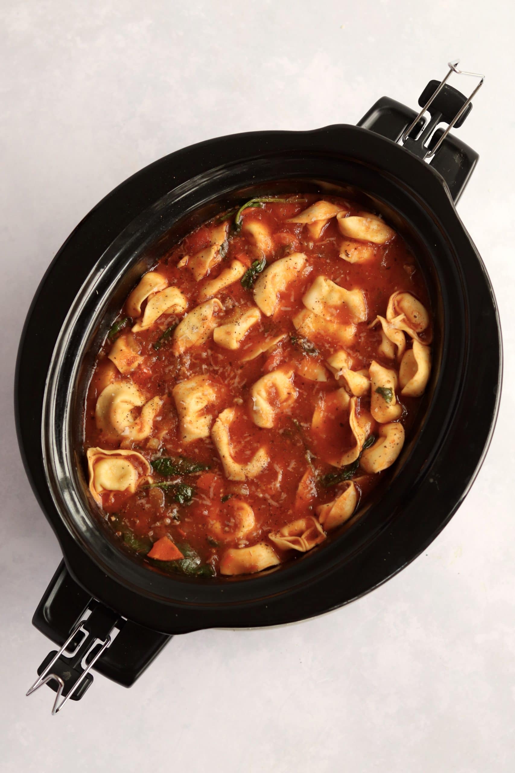 crockpot sausage tortellini soup in the slow cooker.