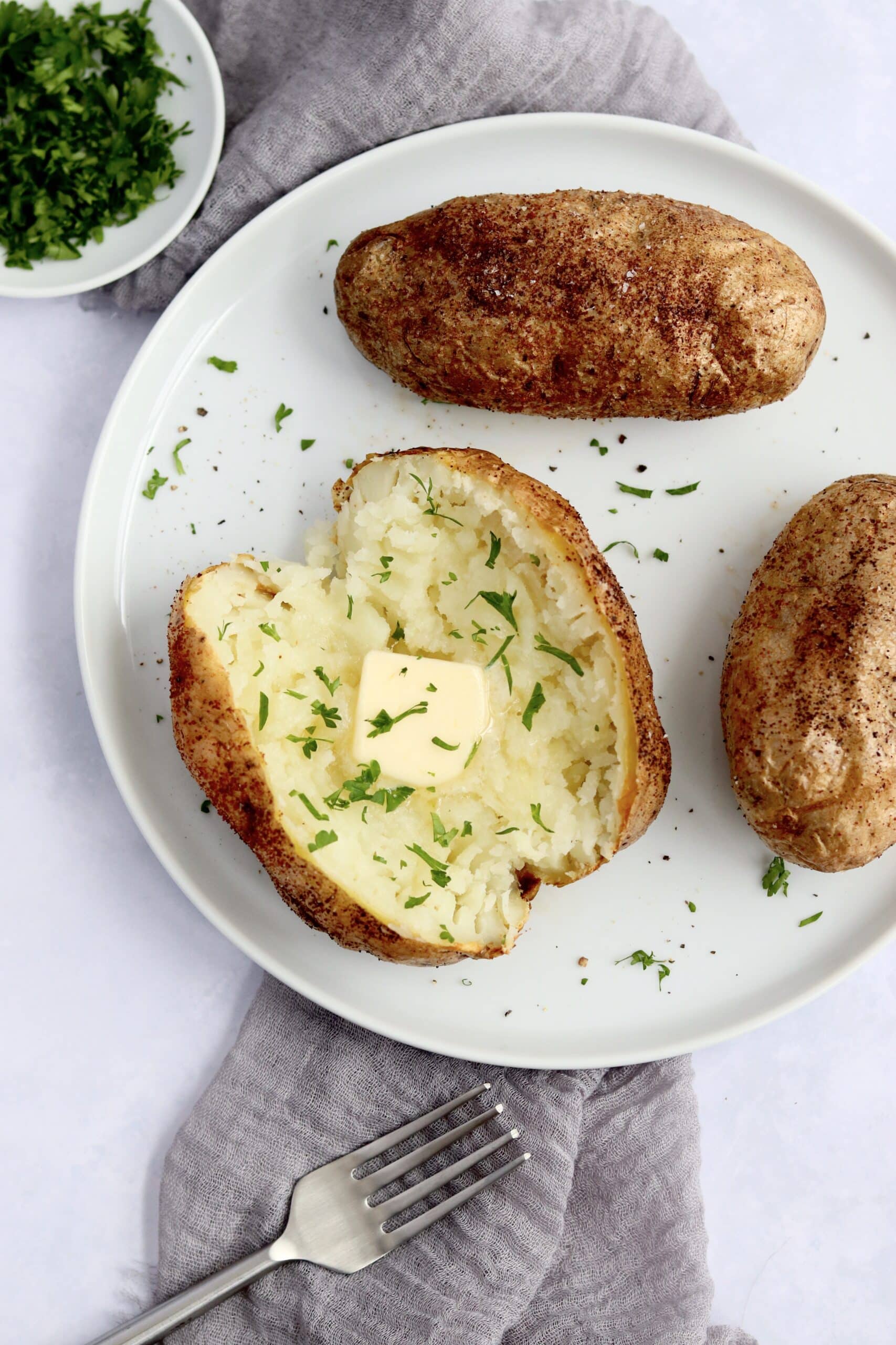Baked potatoes on a plate with butter
