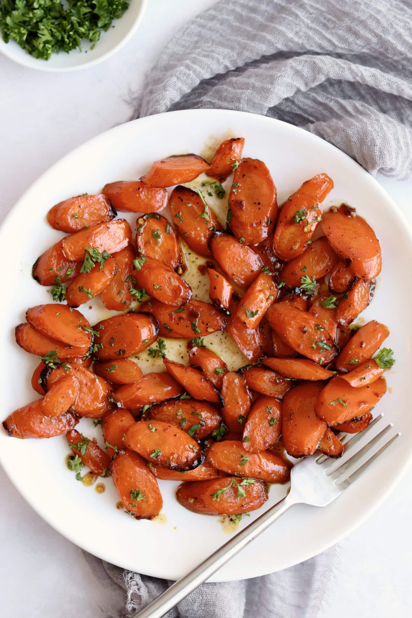 Air fryer honey soy glazed carrots on a plate with parsley