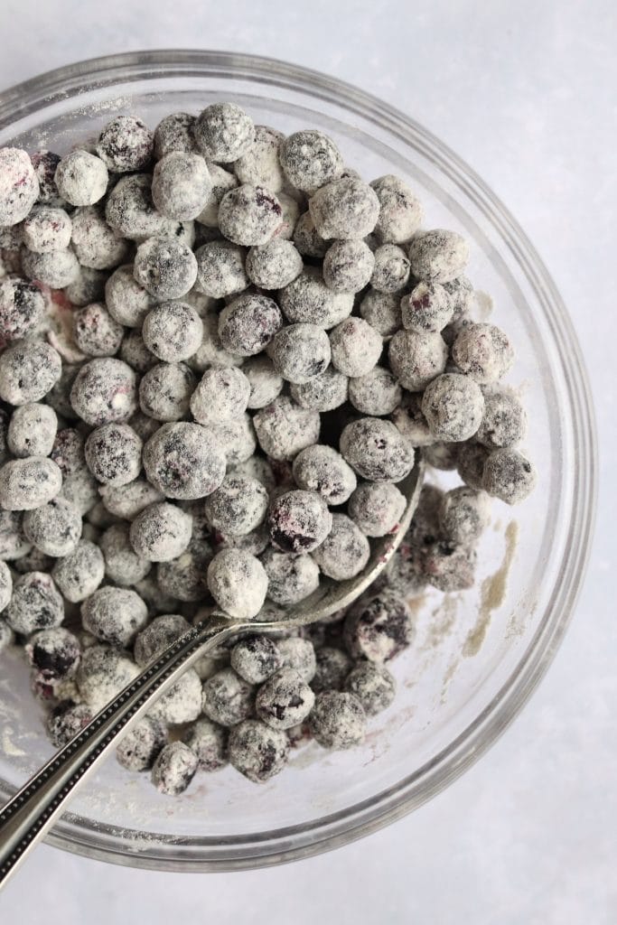 Fresh blueberries tossed with flour in a bowl.