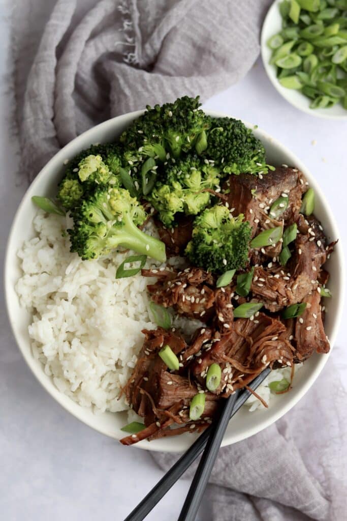 Shredded slow cooker Korean beef in a bowl with rice and broccoli