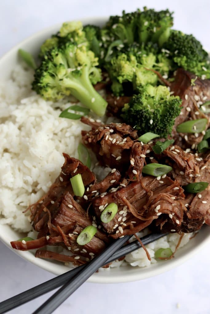 Korean shredded beef with rice, broccoli, and a pair of chopsticks