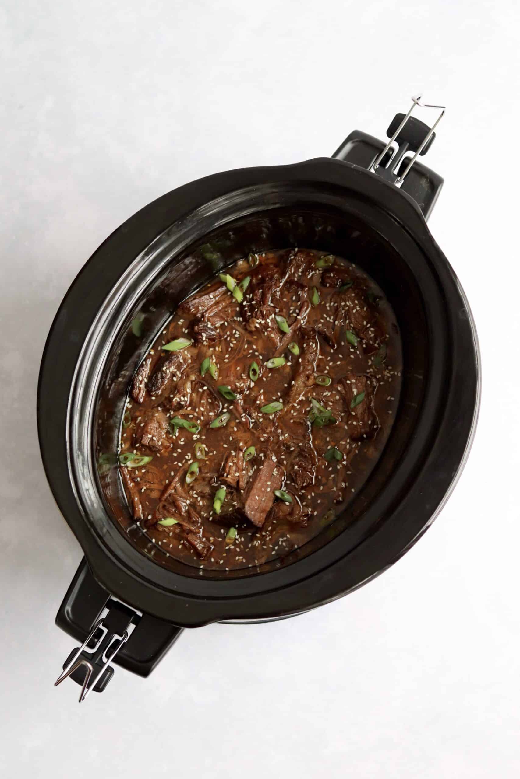 Cooked shredded Korean beef in a slow cooker.