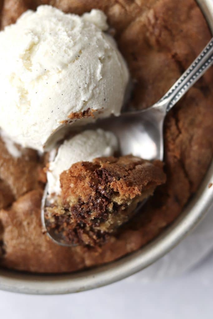 Spoon scooping air fryer chocolate chip cookie with ice cream