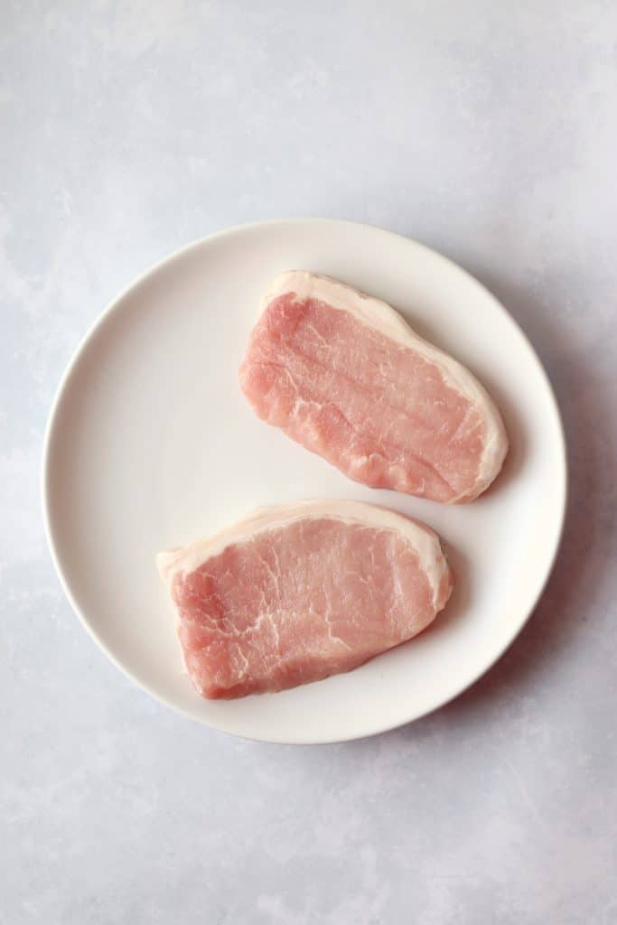 Raw pork chops on plate