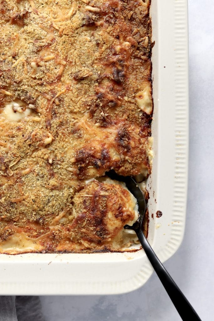cheesy scalloped potatoes with caramelized onions in a baking dish