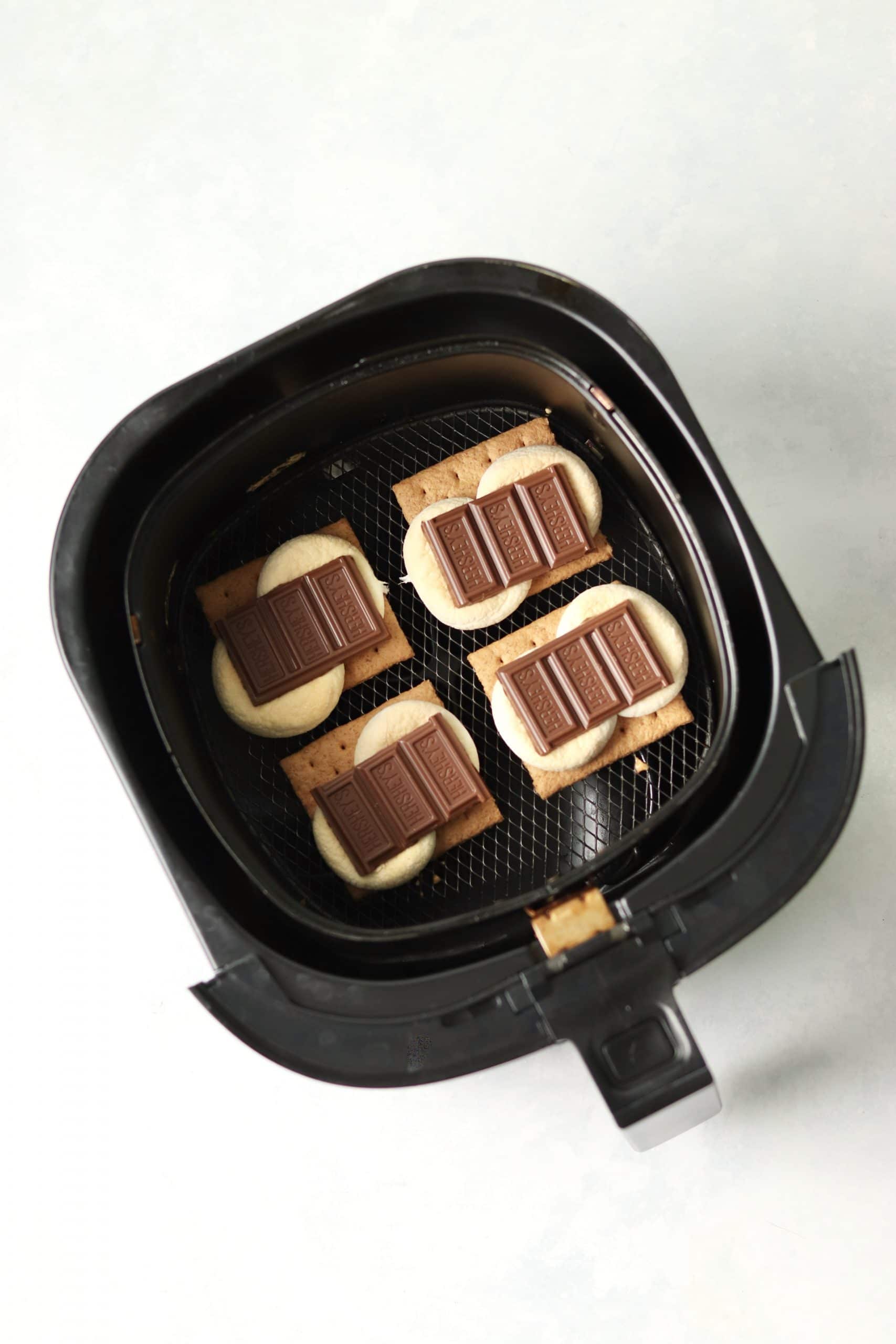 Hershey's chocolate on toasted marshmallows in air fryer basket.