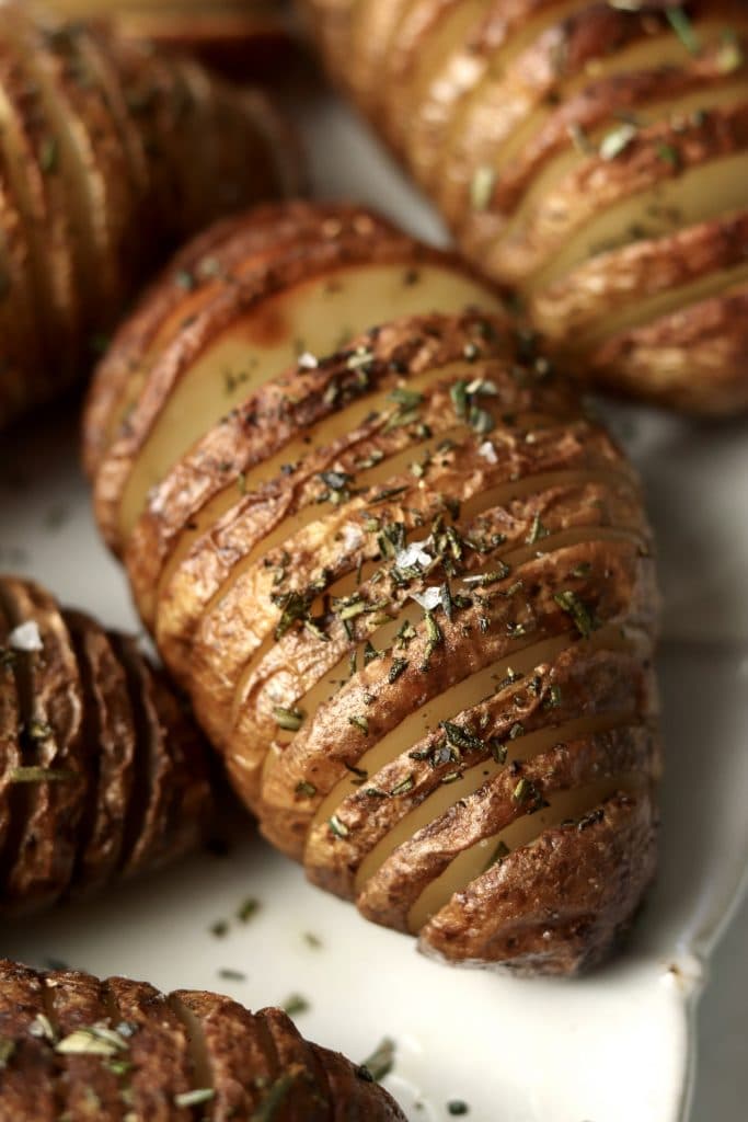 close up of a hasselback potato with flaky salt