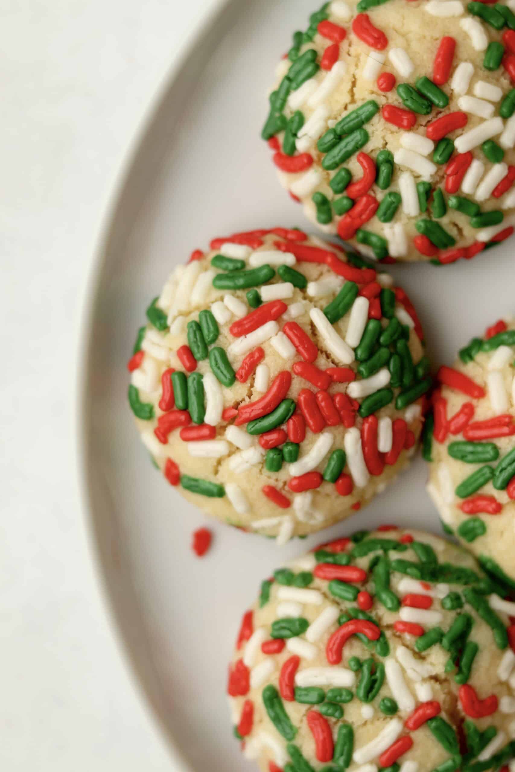 plate of Christmas sugar cookies with sprinkles.