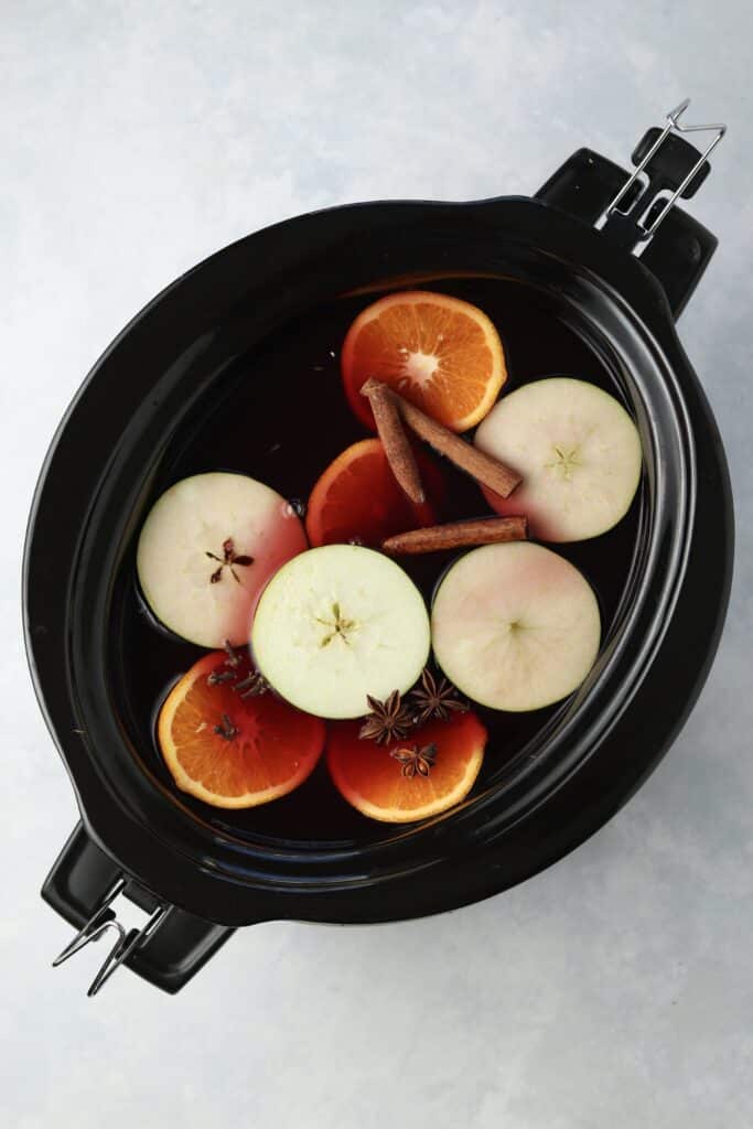 red wine with apples and oranges in crockpot