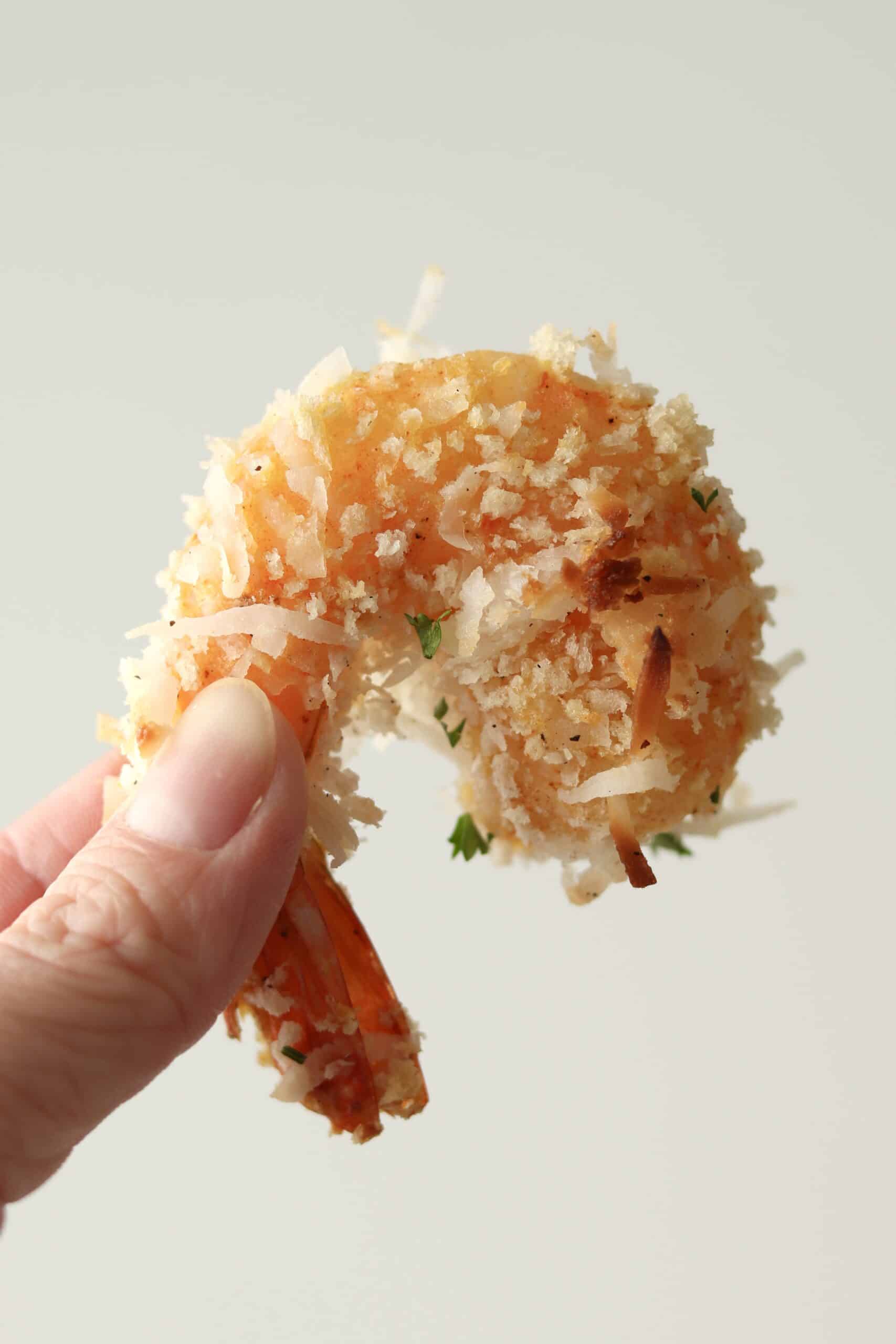 hand holding up a coconut shrimp