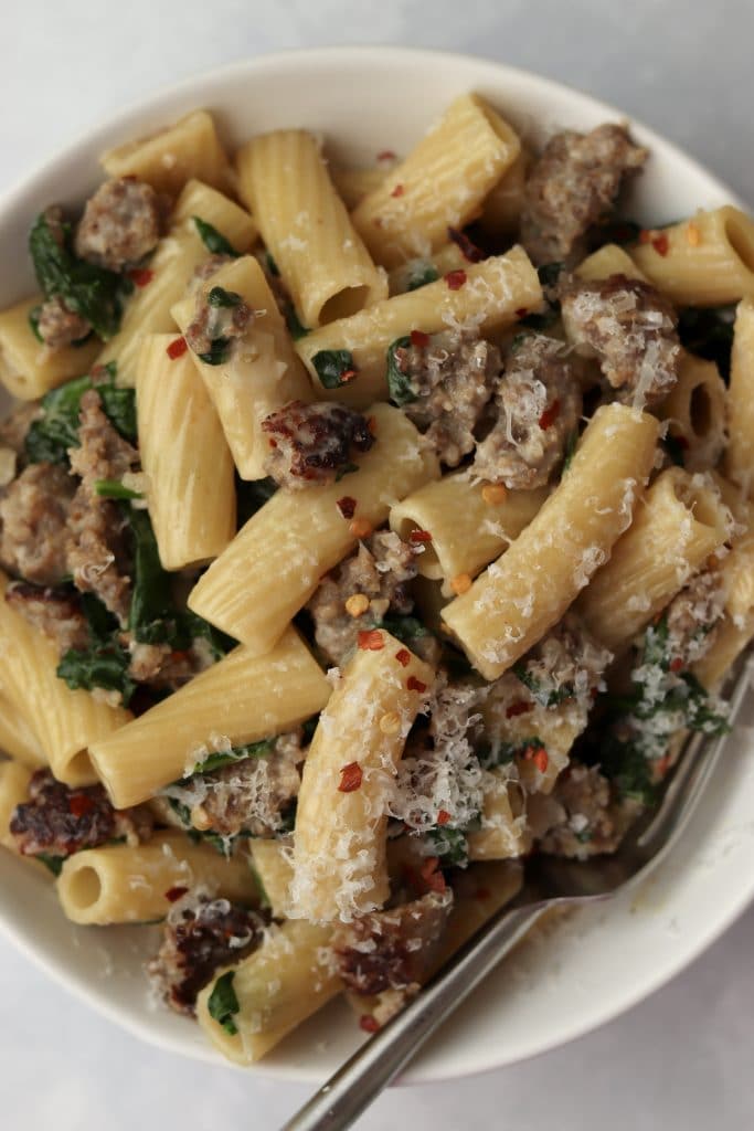 sausage pasta with spinach in a bowl