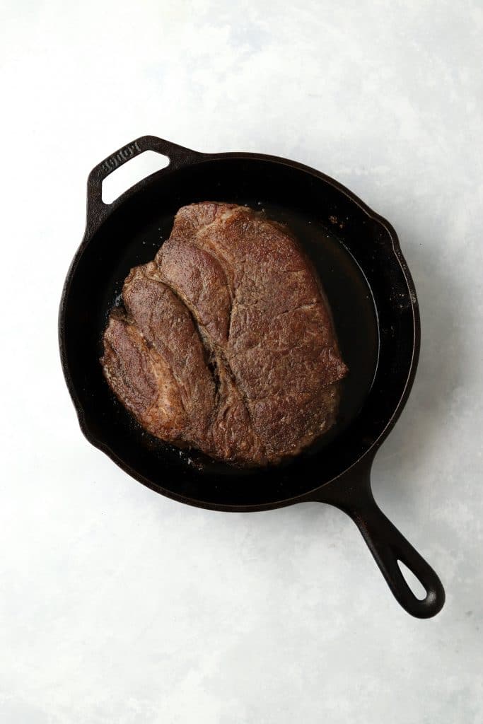 Browned chuck roast in cast iron skillet