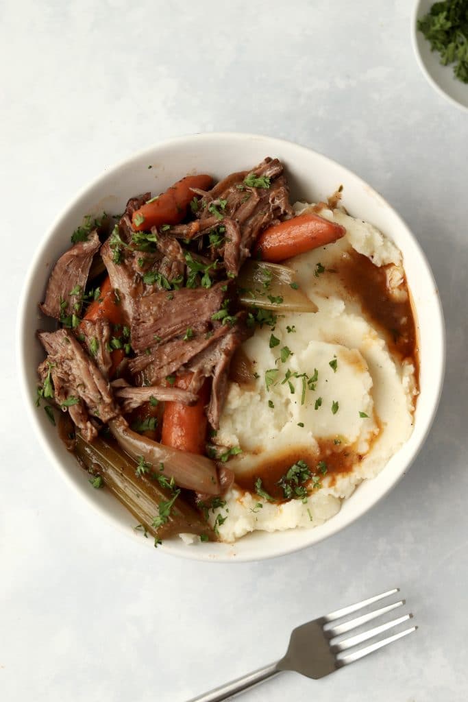 bowl of pot roast with gravy and mashed potatoes