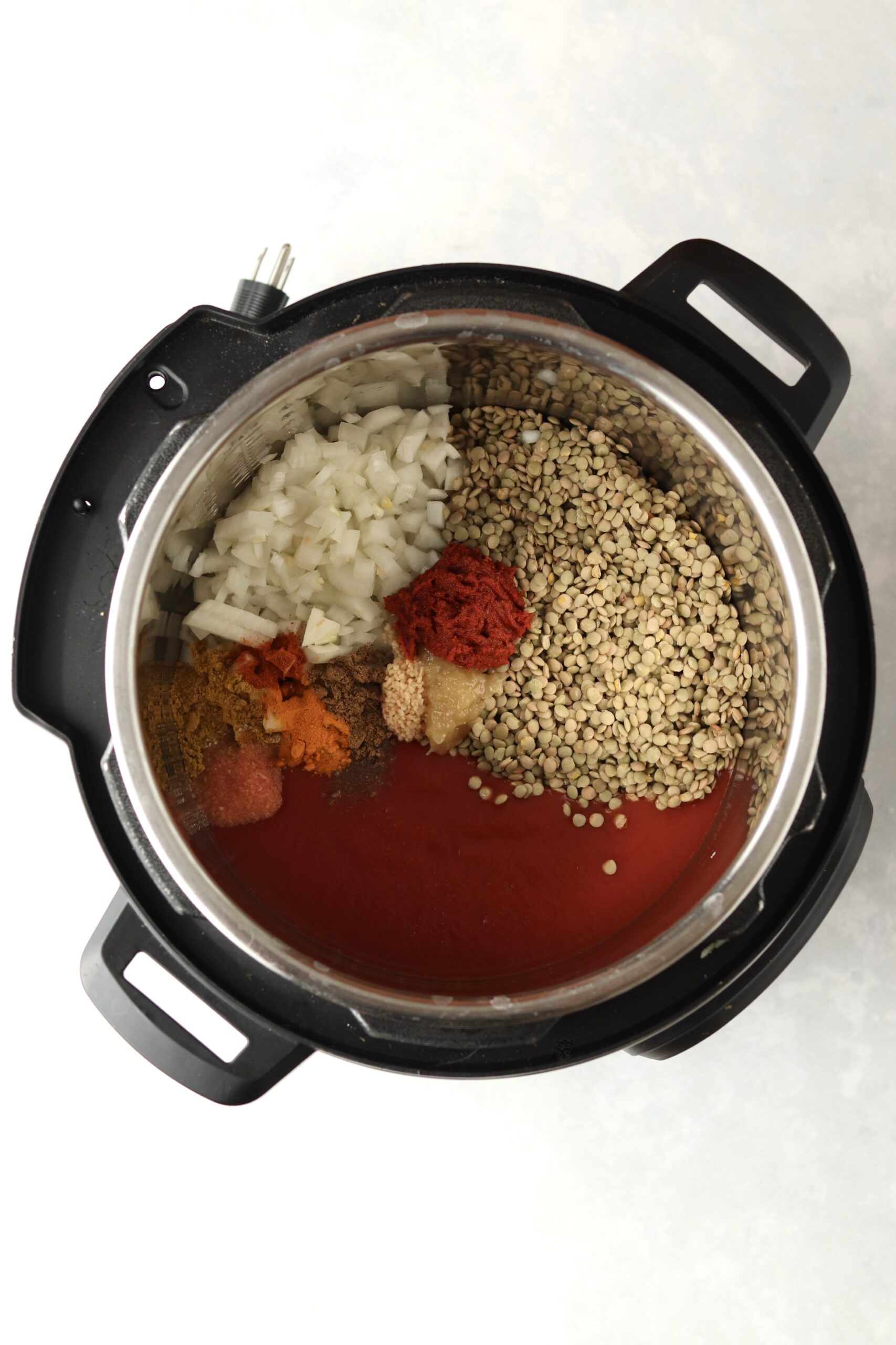 lentils, tomatos, onion, spices, and curry paste in the instant pot