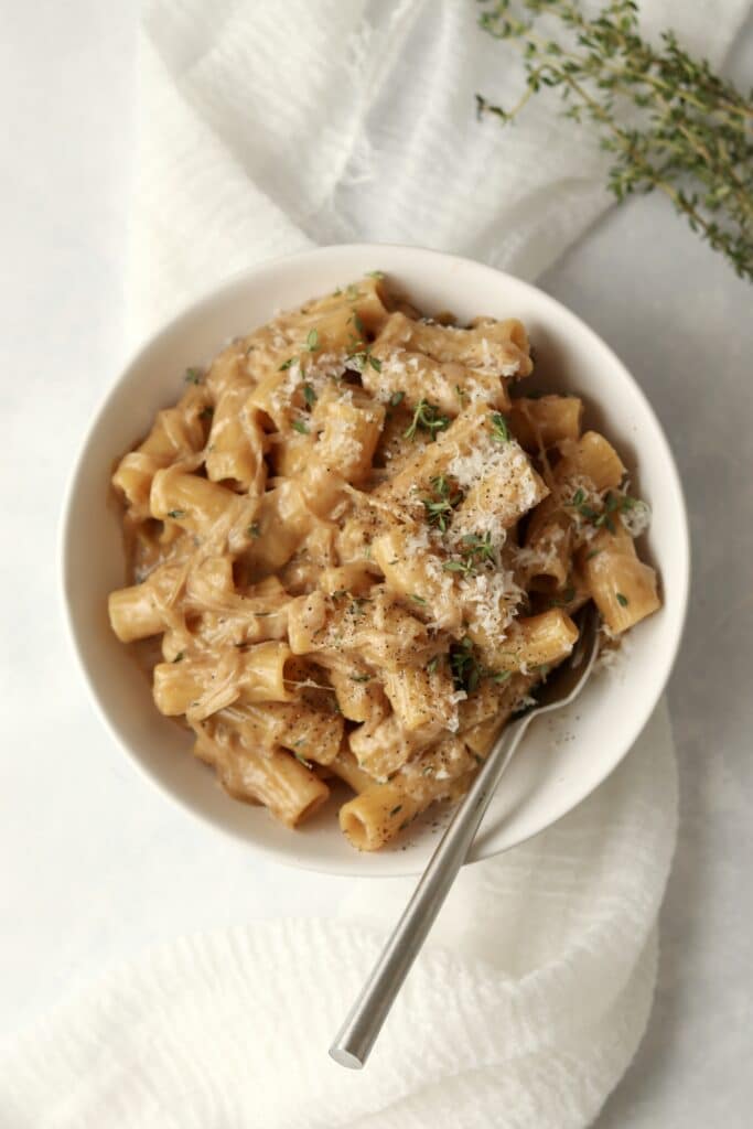 caramelized onion pasta in a bowl with parmesan