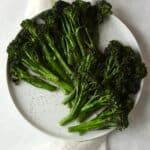 broccolini on a plate with salt and pepper