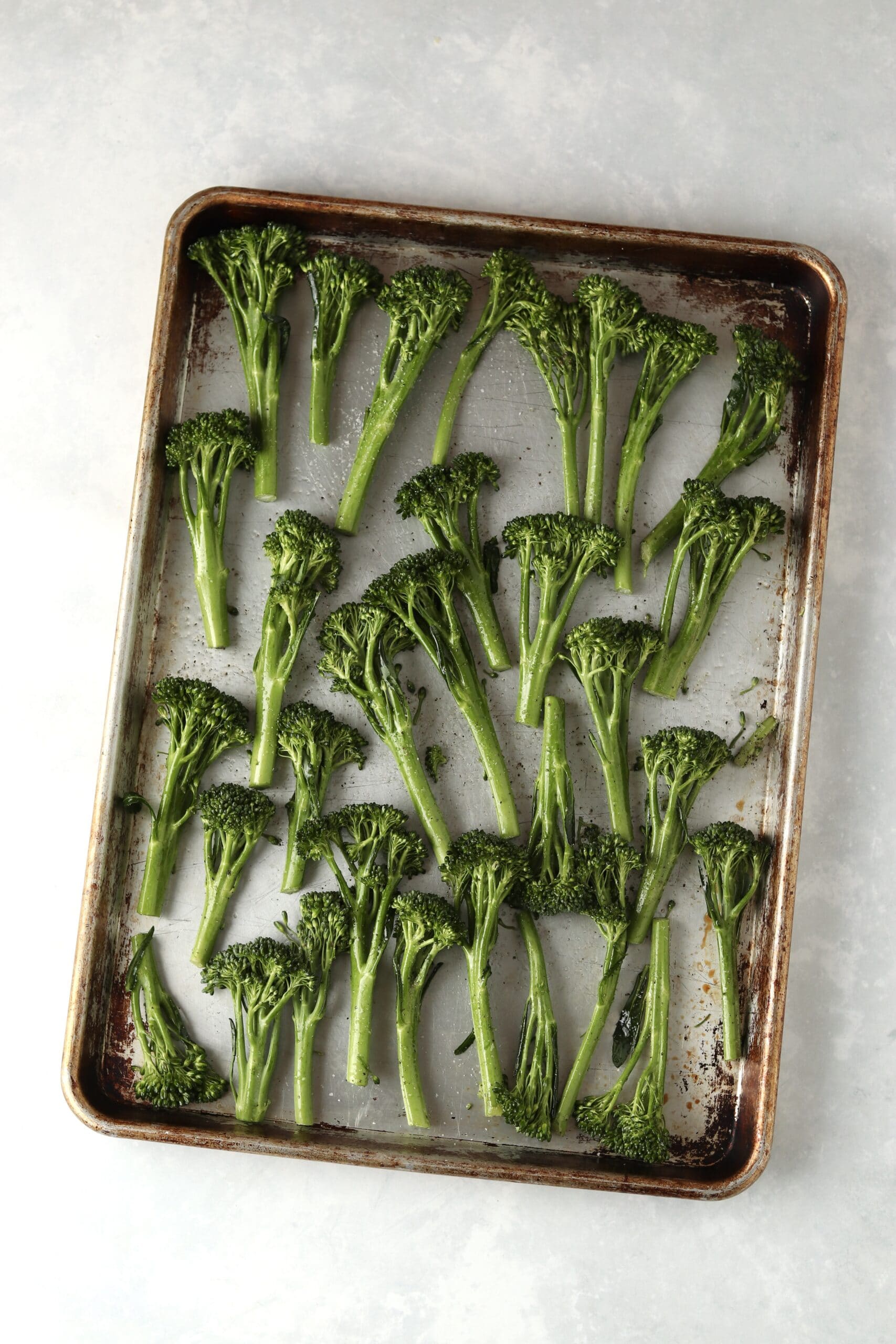 raw broccolini on a sheet pan