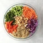 quinoa, carrots, cabbage, peppers, cashew, green onions in a bowl