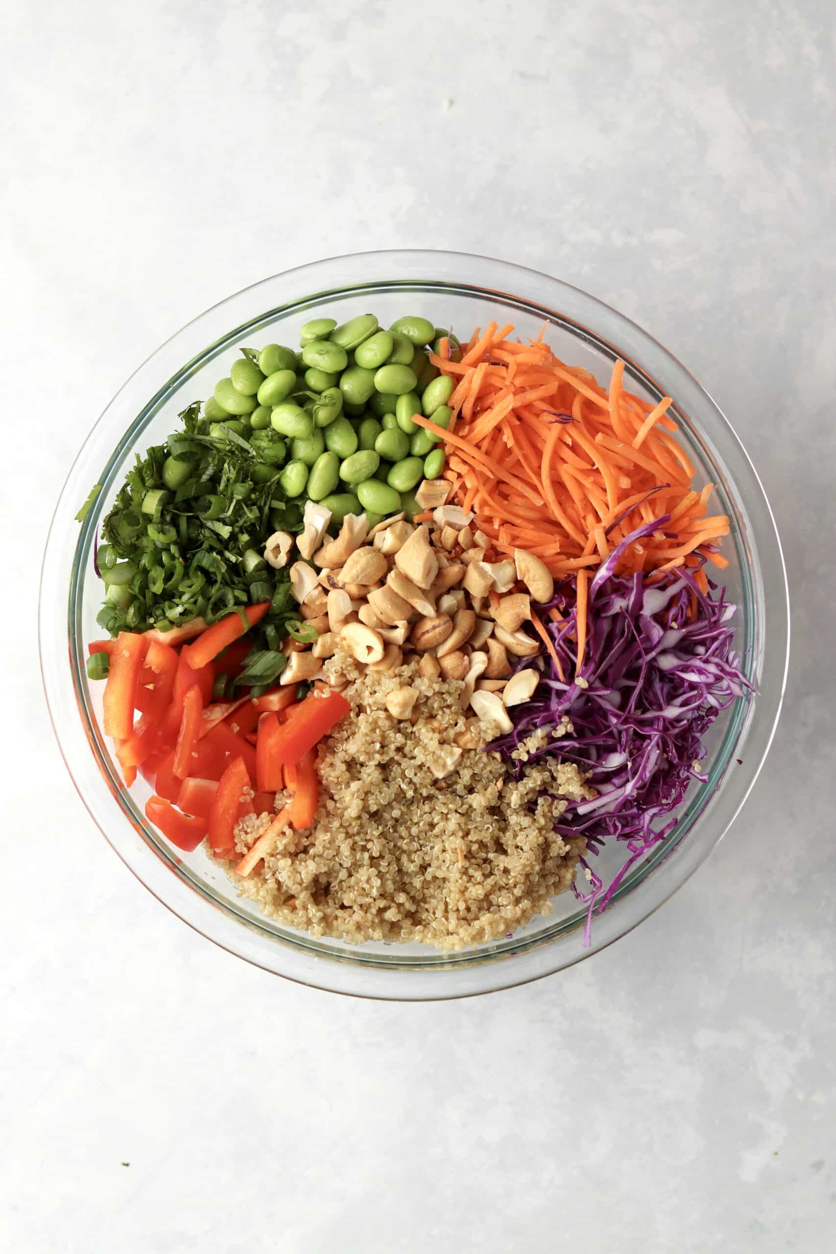 quinoa, carrots, cabbage, peppers, cashew, green onions in a bowl