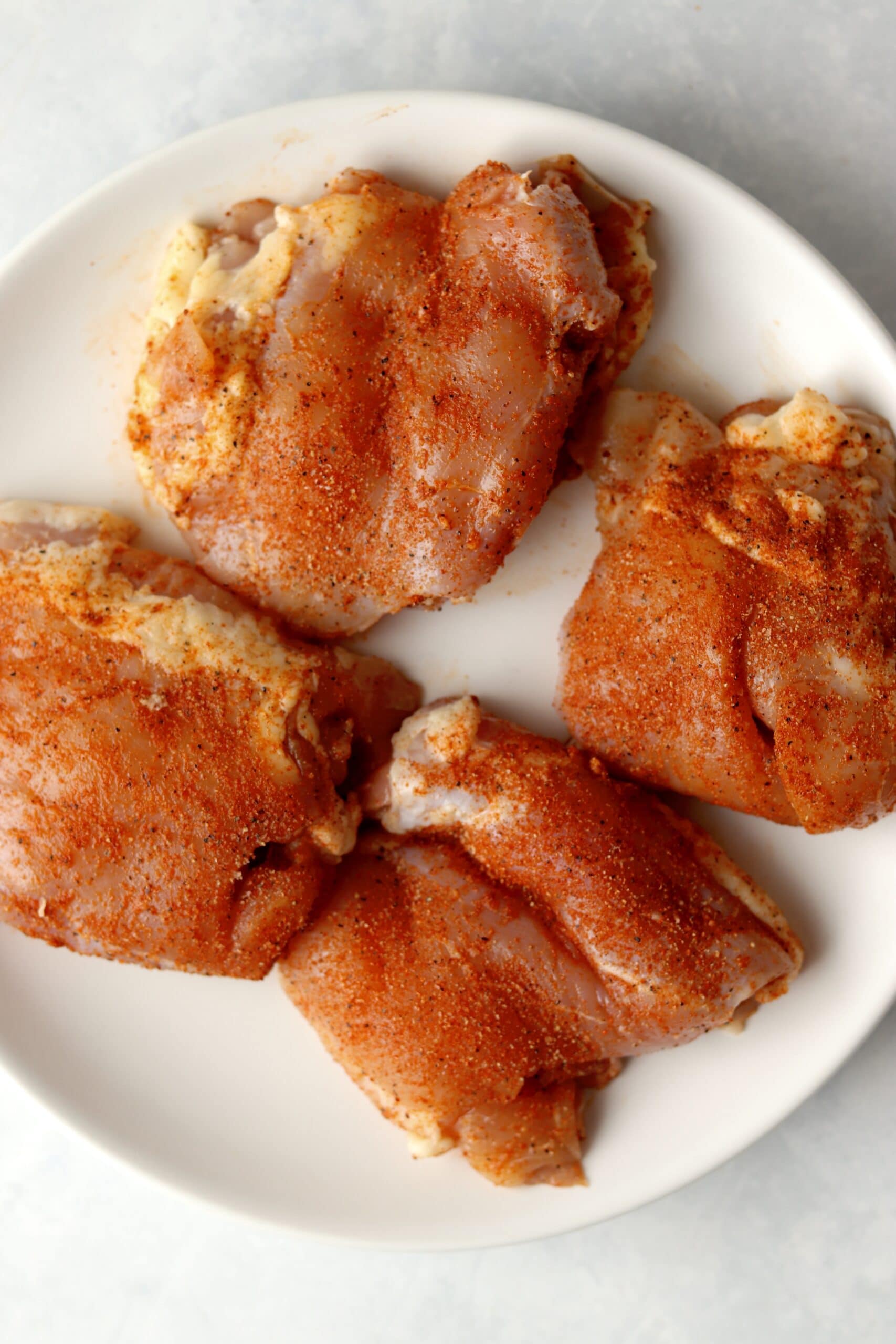 raw chicken thighs rubbed in spices.