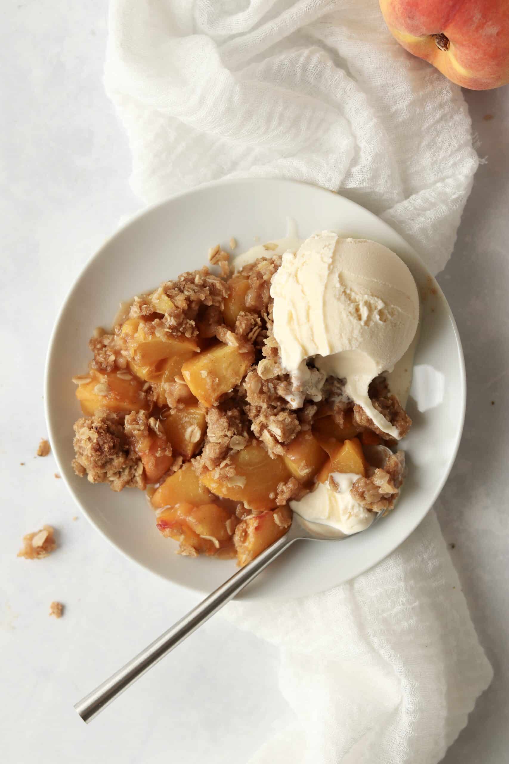 grilled peach crisp with ice cream on a plate
