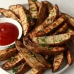 grilled potato wedges with ketchup on plate