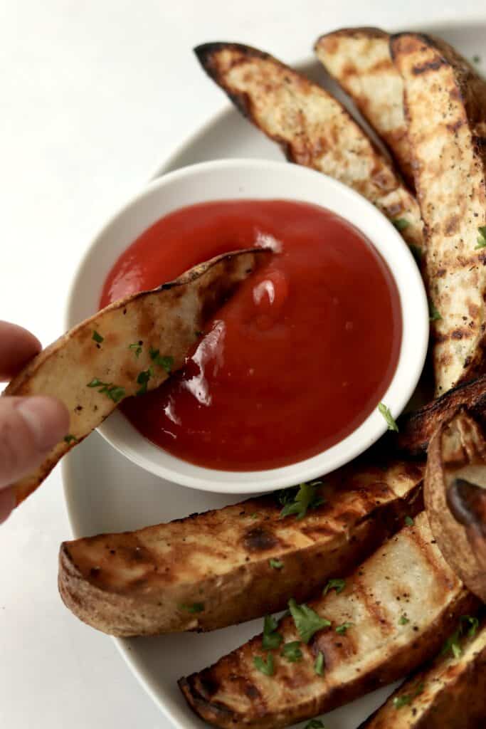 potato wedge dipping in ketchup