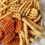 crinkle cut fries and waffle fries on a plate