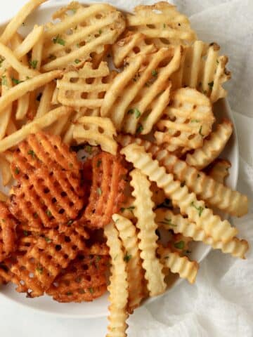crinkle cut fries and waffle fries on a plate