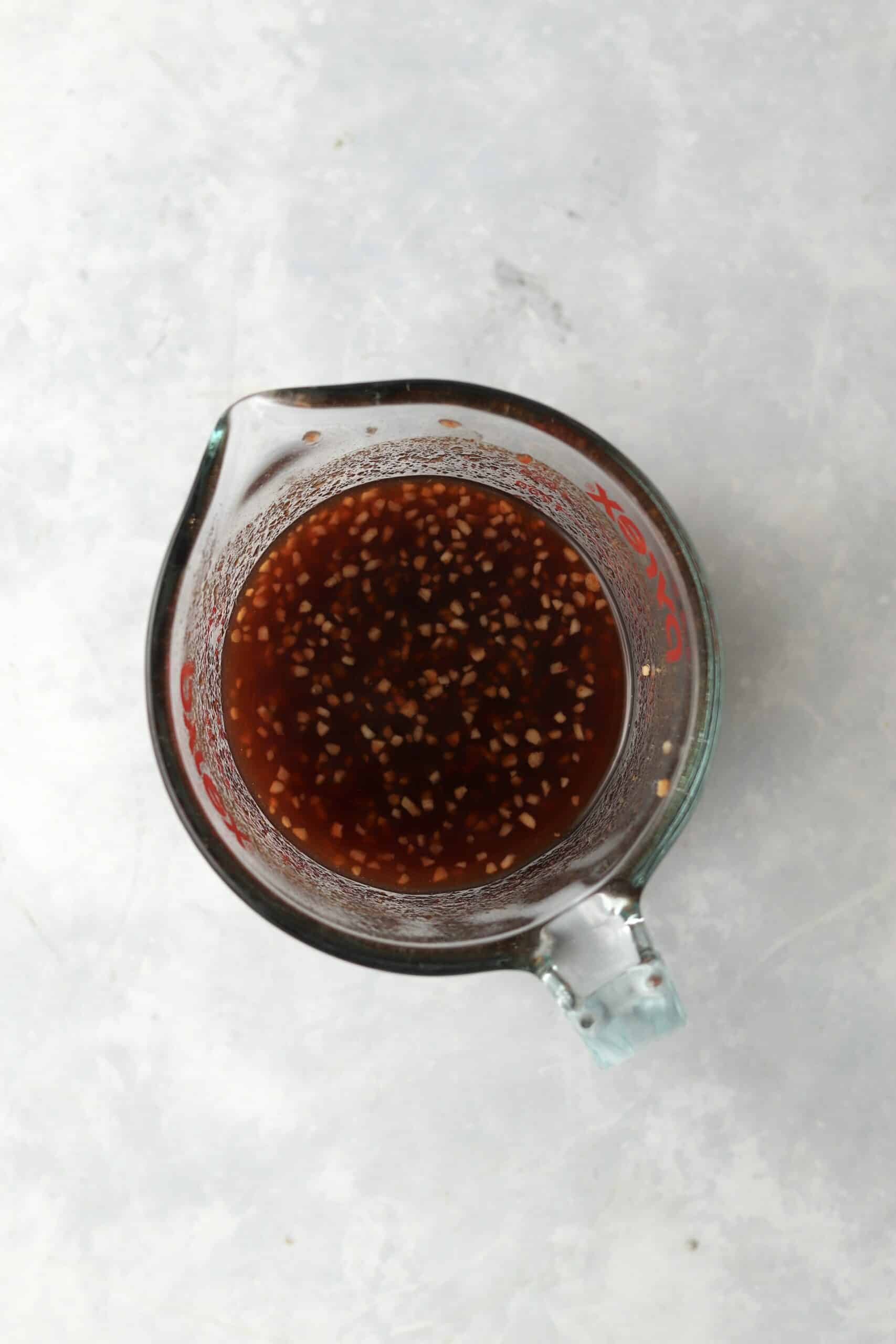 honey sriracha sauce in measuring cup