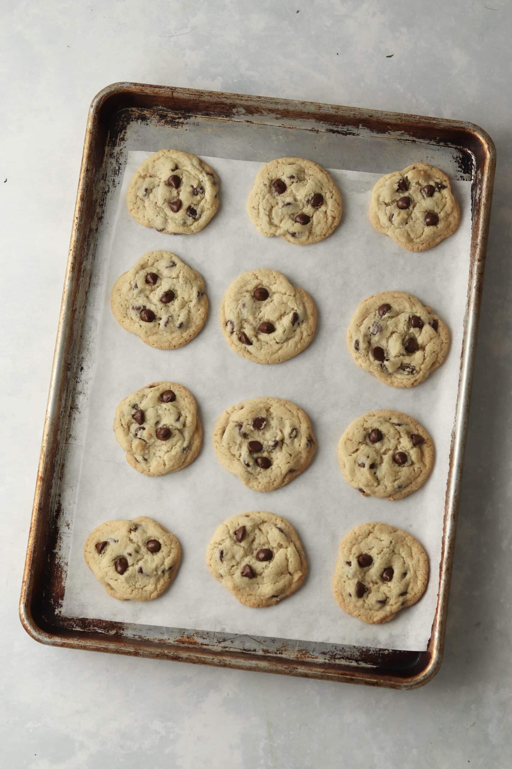 baked chocolate chip cookies on parchment lined baking sheet