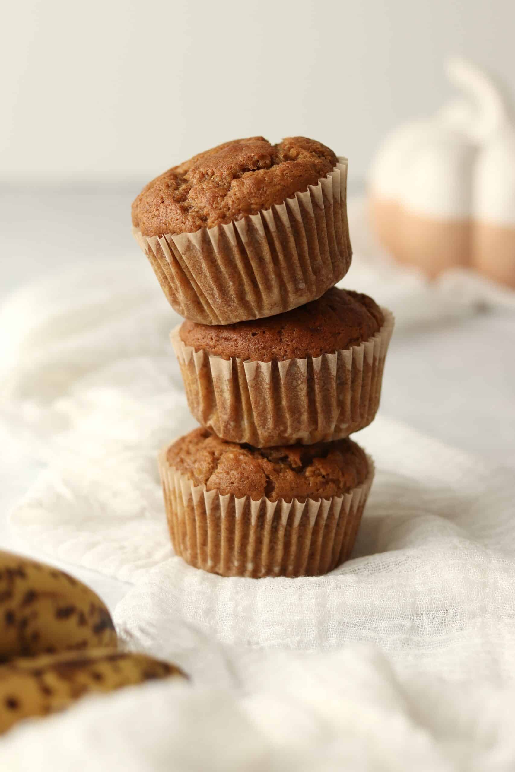 stack of banana pumpkin muffins on a white linen