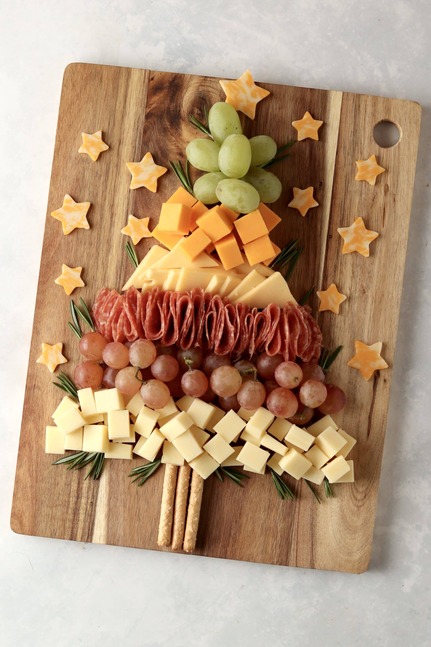 christmas charcuterie board with cheese, meat, and grapes