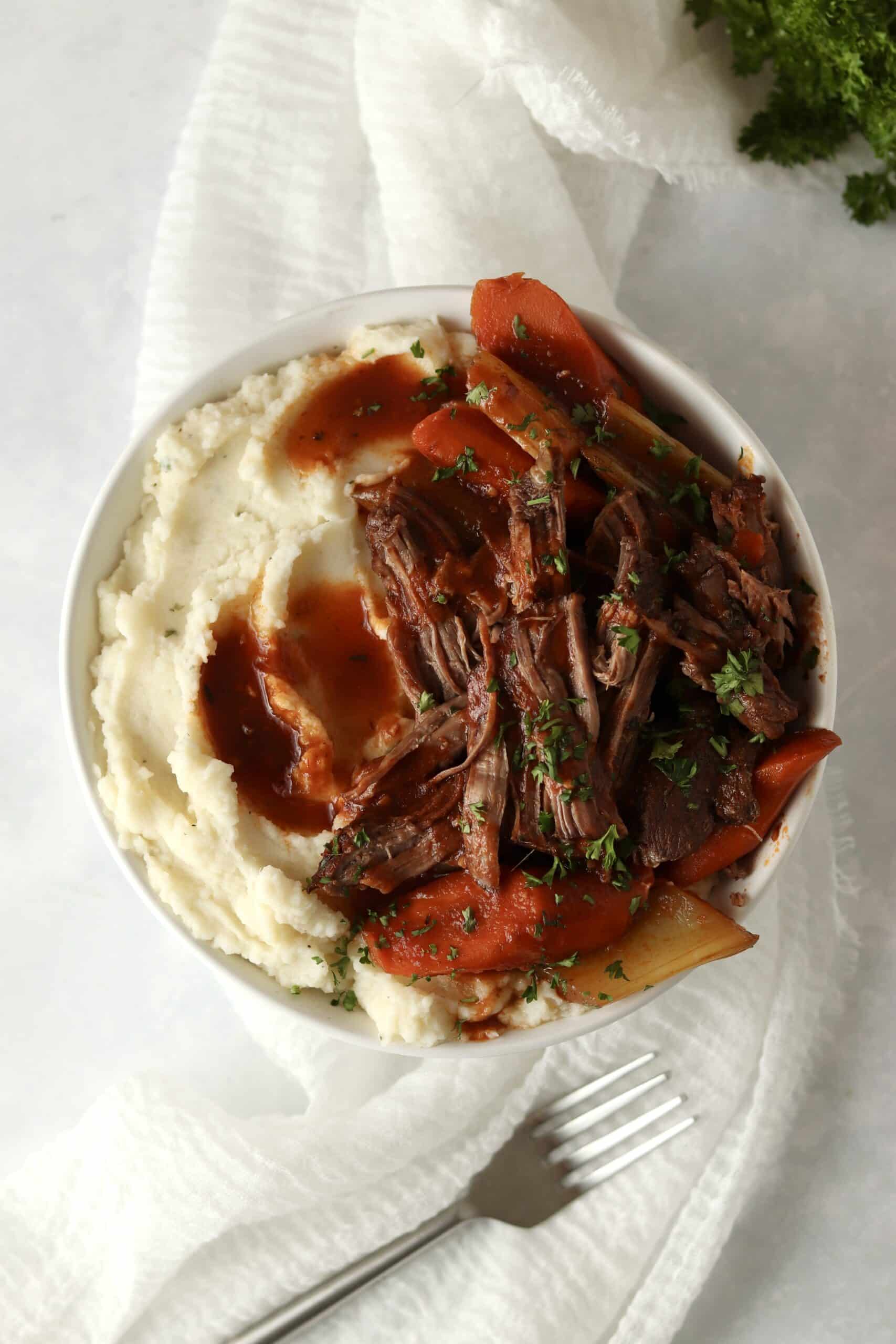 bowl of chuck roast in oven with mashed potatoes