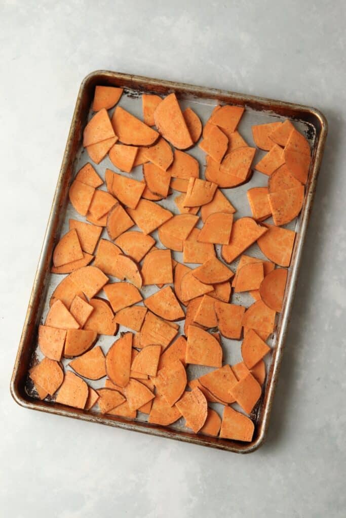 raw sweet potatoes on a sheet pan